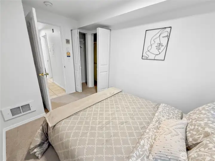 The bedroom has plenty of storage space with an L-shaped closet in the corner.