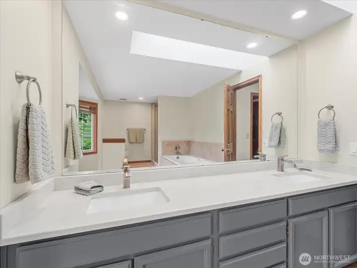 Primary bathroom with quartz countertops and newer sinks. Primary bathroom with quartz countertops and newer sinks.