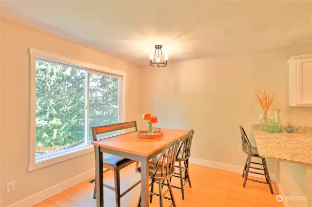 Dining room off kitchen with large picture window facing wooded backyard