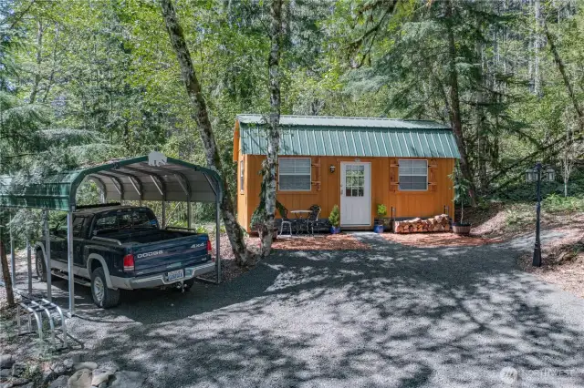 The driveway leads to an additional shed featuring its own patio area and covered parking.