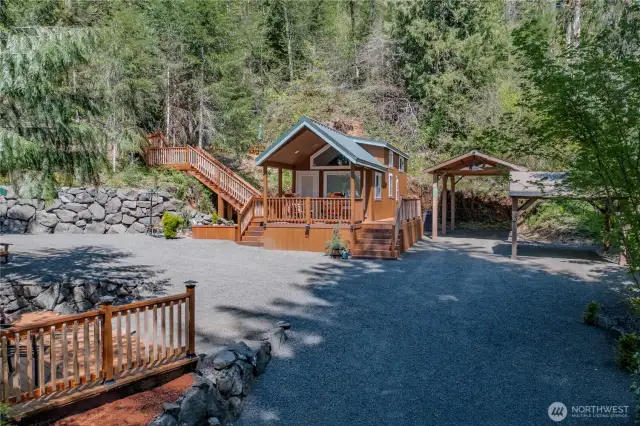 The deck features a staircase leading to the upper portion of the property, with ample covered parking below