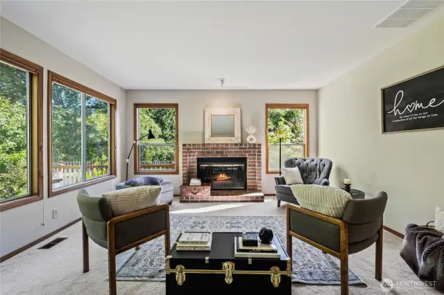 Seating arrangements galore in family room with fireplace.