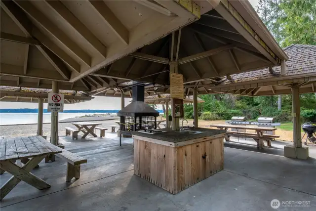 Covered beach side entertainment includes centeral fireplace, sink, and multiple cooking options