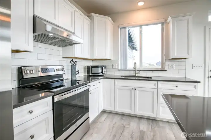 The kitchen features stainless steel appliances, and quartz countertops.