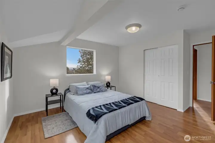 Large primary bedroom with view of the city lights and mountains