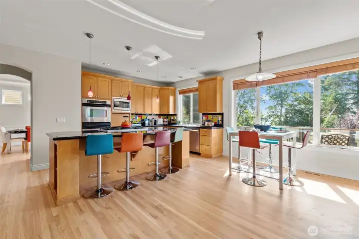 Expansive kitchen and casual dining area with bar seating and direct access to outdoor living.