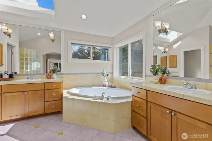 Luxurious primary bathroom featuring dual vanities, soaking tub, and abundant natural light.