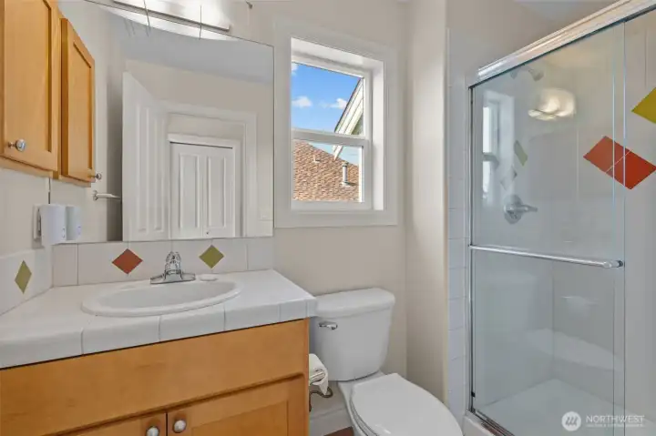 Bright full bathroom with tub/shower combo and natural light.