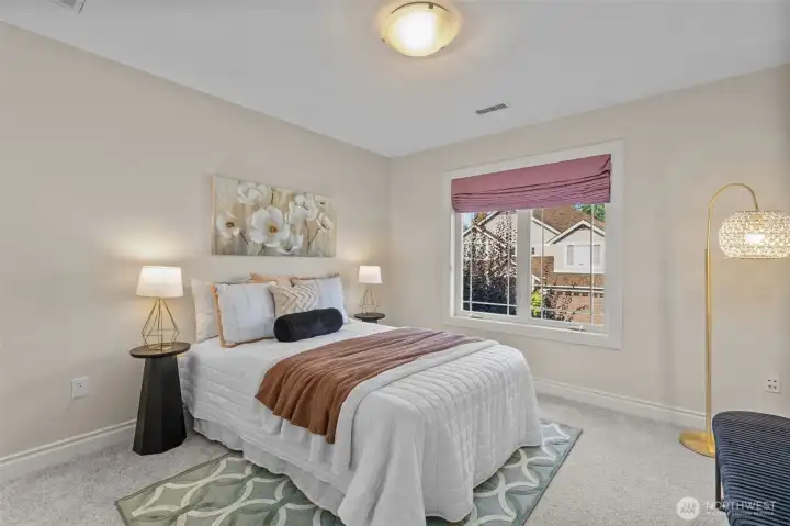 Comfortable guest bedroom with soft natural light and generous closet space.