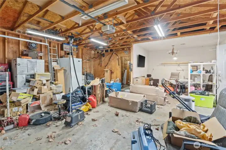 Interior of Garage and Shop Space. There is a Storage Room to the Back Left and Office/TV Room to the Back Right.