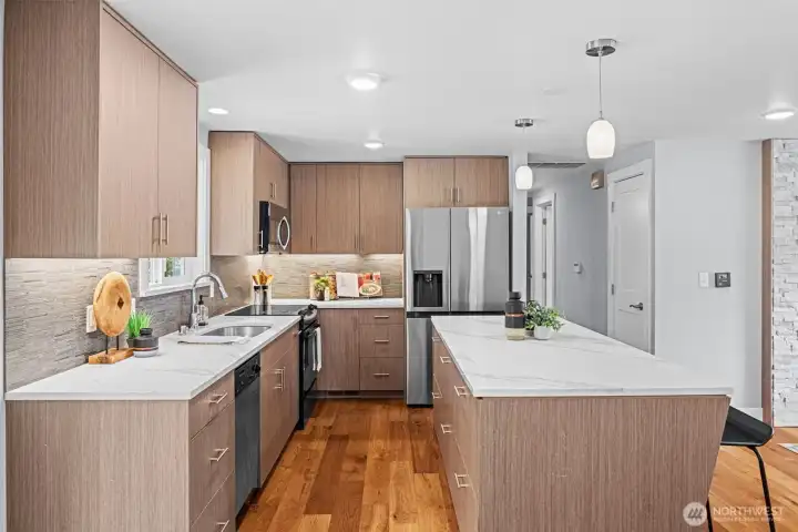 Under cabinet lighting, designer accent backsplash, & quartz countertops. Kitchen appliances stay with the home.