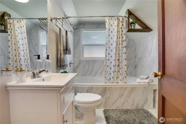 The 2nd full bath is freshly renovated with new flooring, tub, tile surround, and vanity. This large tub is meant for soaking! A privacy glass window allows for light and additional air flow.