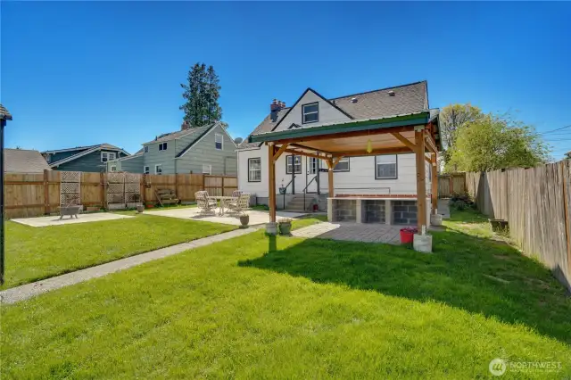 The covered paver patio includes a built-in table where you can set up food and drinks for summer parties.