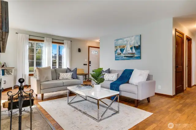 Set at the heart of the home, the living room connects to the dining area and the hall. The door on the right leads down to the basement.
