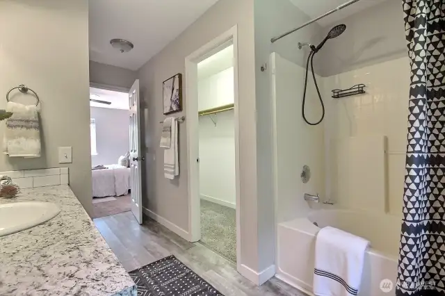 Soaking tub with shower and large walk-in closet.