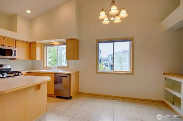 Cathedral ceilings, large windows, dining room with built-in shelves with glass doors.