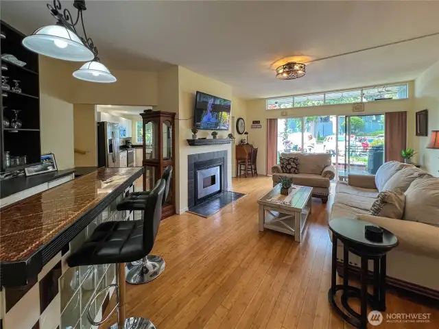 Another view of the living room, bar area and fireplace looking out to the sliding glass doors to the patio.