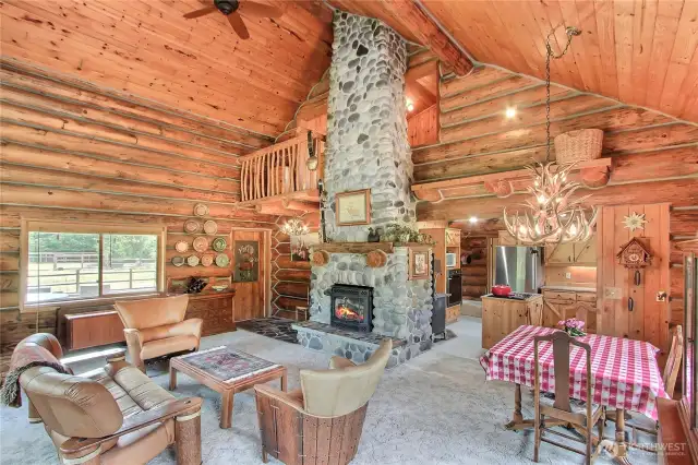 Vaulted great room with floor to ceiling handcrafted rock fireplace. Front door is inlayed with copper art work.