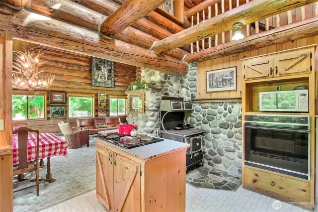 Kitchen with custom pine cabinets and an authentic woodburning cook stove that compliments the modern electric kitchen appliances.