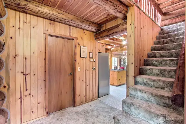 Hallway. Door to laundry room and back deck. Staircase to 2nd floor primary suite.