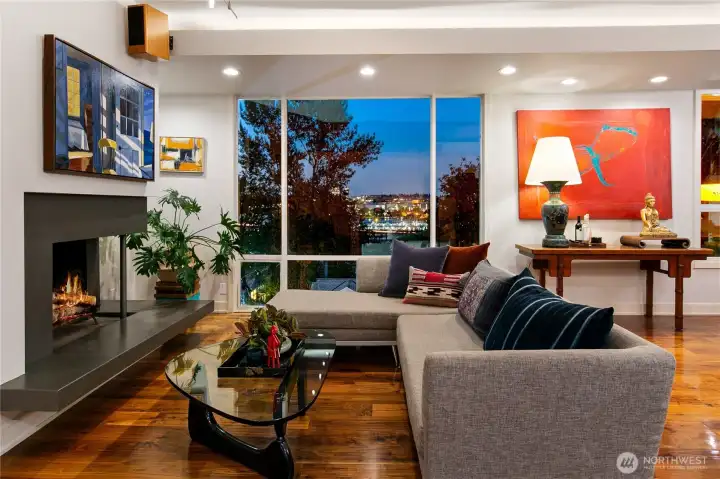 At dusk, the great room glows with warmth against a backdrop of Portage Bay and treetop silhouettes. The balance of granite, walnut, and glass creates a sanctuary where Olmsted’s woodland serenity meets contemporary ease.