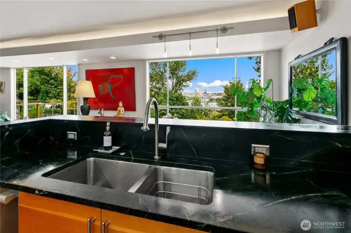 Soapstone counters and a wide stainless sink are framed by windows that open directly to the treetops. Even the most everyday routines feel elevated, with Olmsted’s parkland always in view.