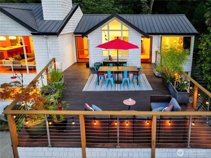 The dining and living rooms spill naturally onto an elevated deck, extending the home’s heart into the open air. Here, meals and gatherings take on a parkland backdrop, where Olmsted’s woodland and evening sky become part of the setting.