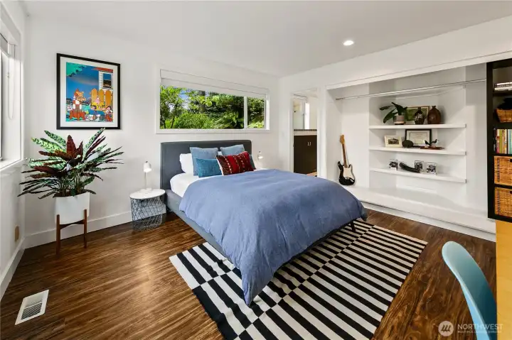 The garden level hosts two full bedroom suites, each with its own bath, plus a fourth bedroom for added flexibility. Together they expand the home’s capacity for guests, multigenerational living, or dedicated workspaces—always with Olmsted’s woodland just outside.