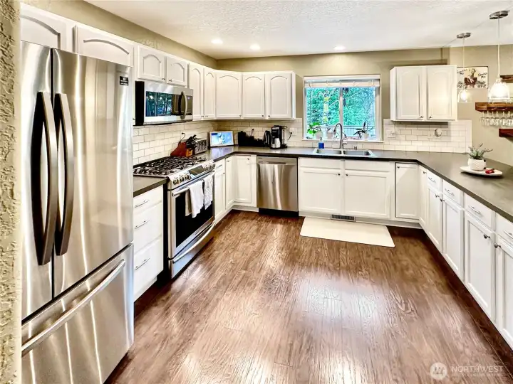 Ample kitchen features lots of cabinets, stylish subway tile backsplash, updated high-end appliances including gas stove. Open to family room perfect for entertaining.