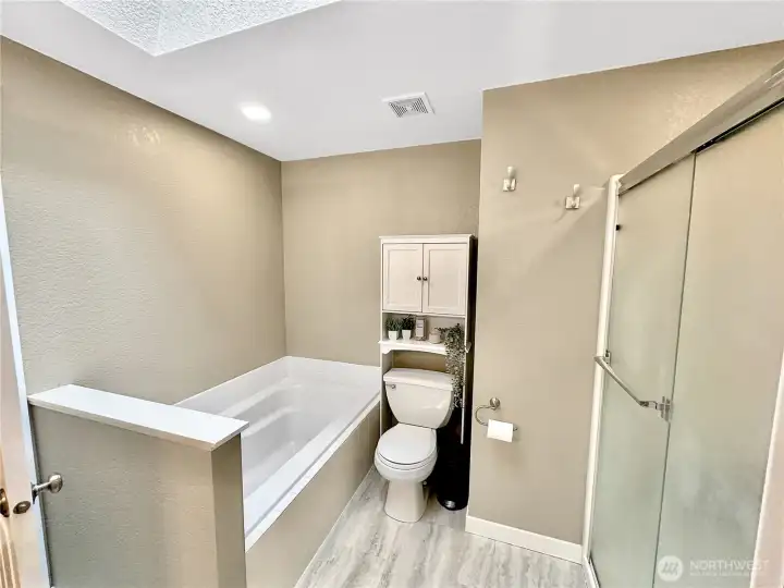View of primary soaking tub and separate shower.