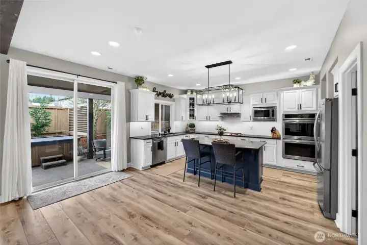 All appliances stay for buyer convenience! Double oven, gas stovetop with matching stainless steel vent hood, and built in microwave are great features to have. Under and over cabinet accent lighting controlled by small remote. Slider door for easy patio access!