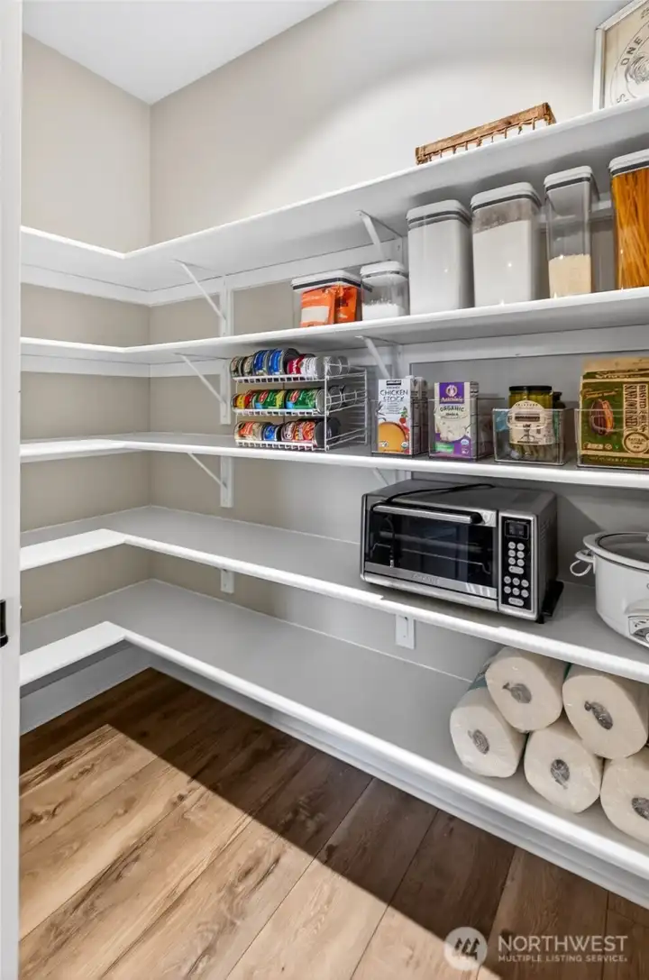 Oversized walk-in pantry features 5 freshly re-finished wrap-around wood shelves. Pantry light is motion activated.