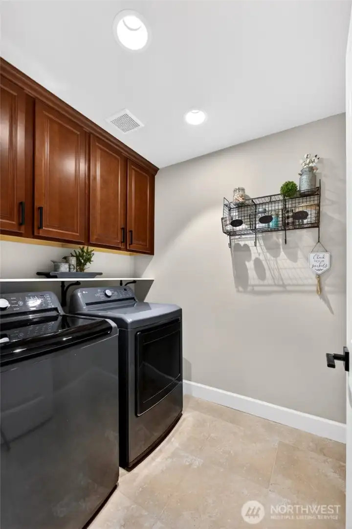 Convenient upstairs laundry room with tile floors, cabinets for extra storage, and a built-in shelf above the washer & dryer. Washer & dryer included. Light is motion activated.