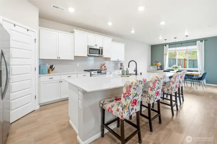 Crisp white kitchen with massive quartz island for gatherings, meal prep and fun!   Be sure to check out the large pantry!