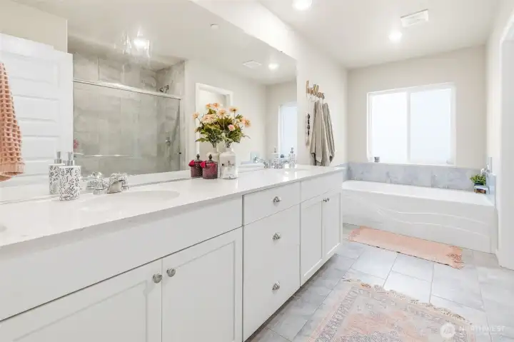 Primary Bath features a relaxing soaking tub and separate shower, quartz counters on a dual sink vanity.