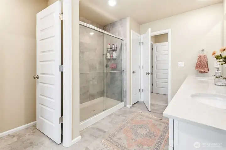 Separate toilet closet and roomy tiled shower in the primary bath.