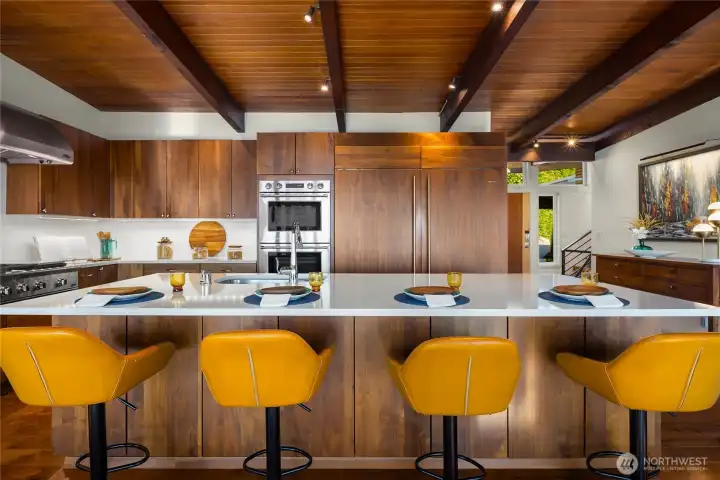 Walnut cabinets, quartz countertops, luxury appliances. Large island includes seating for four.