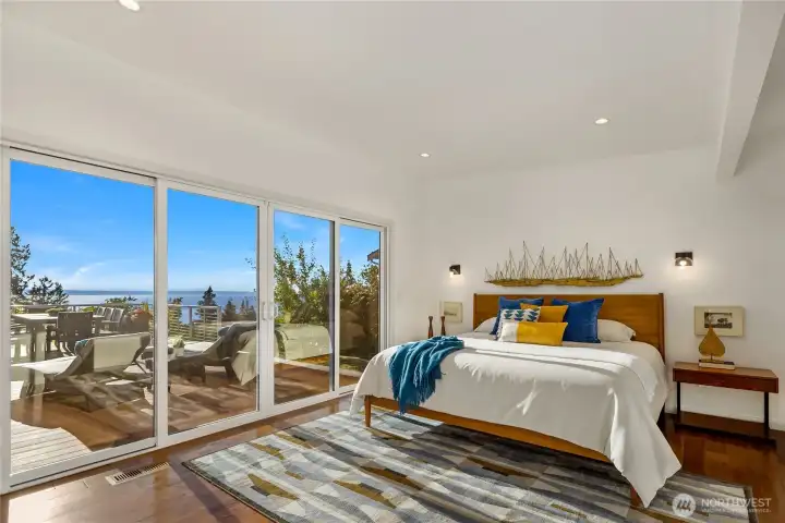 Primary suite with hardwood floors and sliding glass doors that lead to private side of deck. Views of the San Juans.