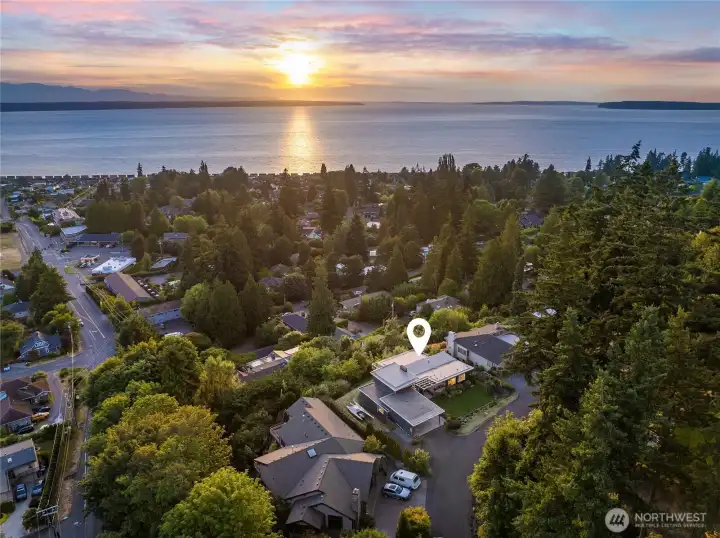 Aerial view of the property facing west, looking at the sunset. The home sits on a private gated road shared by only a few homes. Underground electricity and a recently paved road.