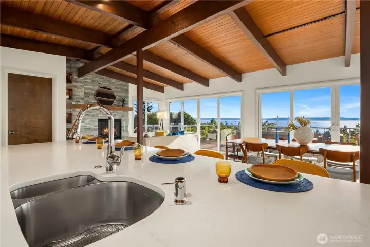 View from the huge kitchen island. Double-sided stainless steel sink with modern motion sensor faucet.