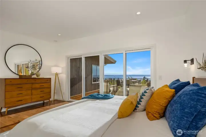 Primary suite with double-wide sliding glass doors that lead to the side section of the deck. Infinite views of Puget Sound, the Olympic Mountains, downtown Edmonds, and the peninsula.