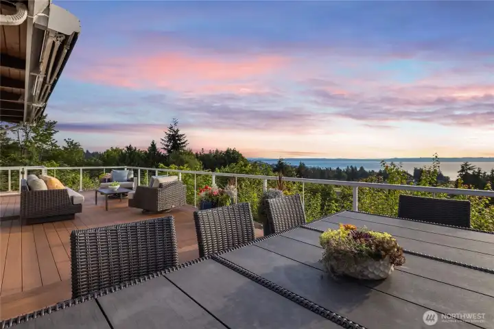 Outdoor dining area facing southwest. The deck features two retractable awnings to provide shade and enhance comfort for the outdoor space year-round.