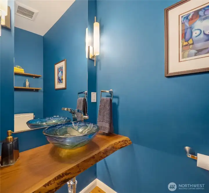 Powder room off the kitchen, near the entrance, hidden by a pocket door and perfect for guests.