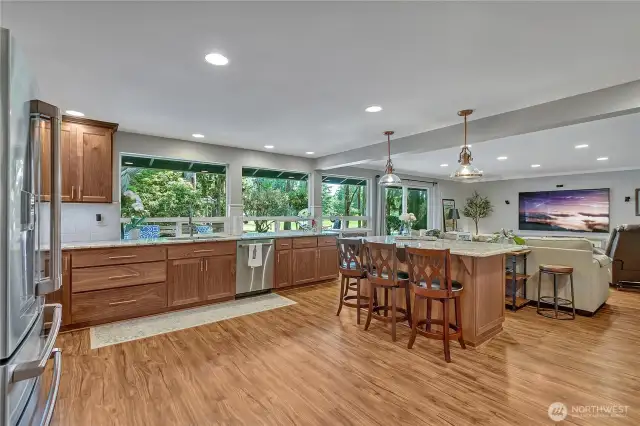 Kitchen and Great Room with slider to deck and golf course.  Newer LVP flooring for ease and beauty. Wall of windows and glass slider to deack. Canned lights galore!!