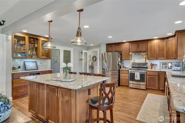 Full kitchen & Island.  Note built-in glass fronted cabinet on the left.  Walk-in pantry.  French Door entry from hallway.  Black walnut cabinets, granite counters, copper pulls, even on the refrigerator!