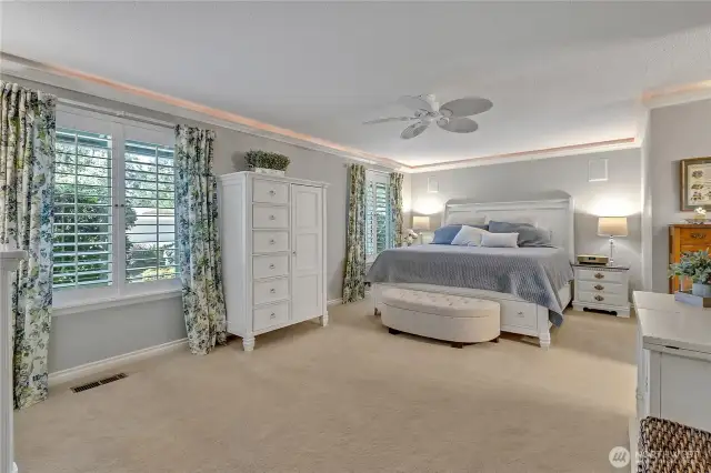 Primary suite with Plantation shutters, soft crown molding lighting & smartly designed ceiling fan.