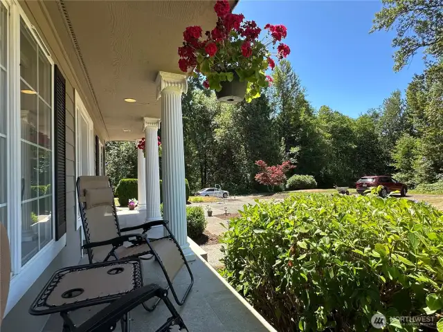 Covered and lighted front porch overlooks overlooks private, West facing-front yard.