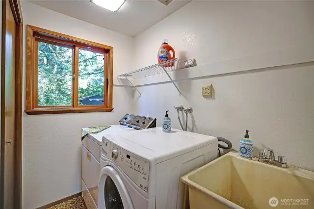 The laundry room is located at the end of the hallway, and next to the interior garage door.  There are new shelves in the closet and above the washer.
