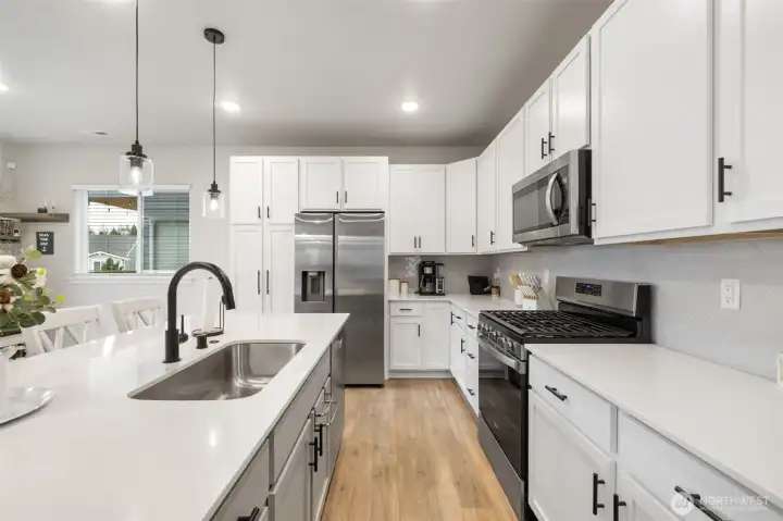 Modern kitchen with gas cooking and designer backsplash.