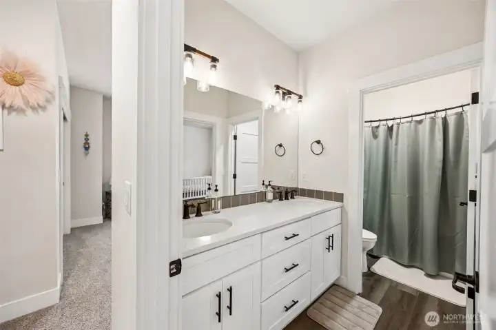 This full-bathroom with dual-sink vanity, door separating sink area from toilet & tub area. Dual entries join the 3rd & 4th bedrooms.